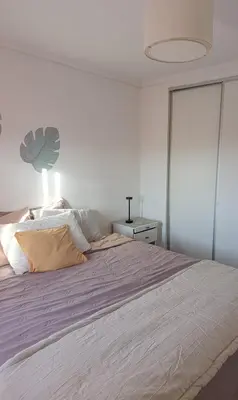a bedroom with a large bed with a purple blanket at HOUSING- Vistas a las sierras-Departamento temporario amoblado in Cordoba