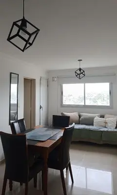 a dining room with a table and a couch at HOUSING- Vistas a las sierras-Departamento temporario amoblado in Cordoba