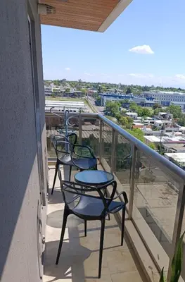 a balcony with four chairs and a view of the city at HOUSING- Vistas a las sierras-Departamento temporario amoblado in Cordoba