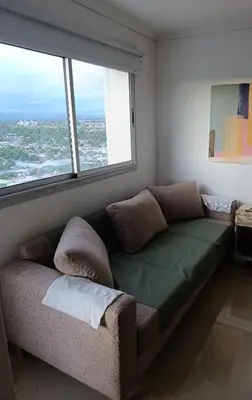 a couch in a room with a large window at HOUSING- Vistas a las sierras-Departamento temporario amoblado in Cordoba