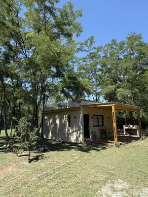 a small house in a field with trees at Ideal para parejas en Anisacate in Villa Anizacate