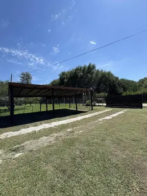 a wooden pavilion in a field with trees in the background at Ideal para parejas en Anisacate in Villa Anizacate
