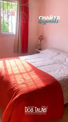 a bedroom with a bed with a red blanket at Calamuchita Apart Dos Talas in Santa Rosa de Calamuchita
