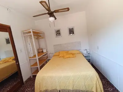 a bedroom with a bed and a ceiling fan at En lo de Ana in Villa Dolores