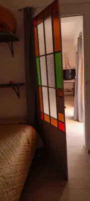 a stained glass door in a bedroom with a bed at En lo de Ana in Villa Dolores