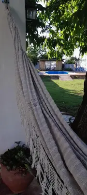 a hammock hanging on a porch with a plant at En lo de Ana in Villa Dolores