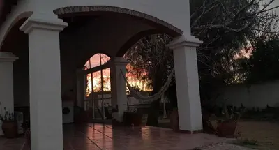 a building with an archway with a reflection of the sunset at En lo de Ana in Villa Dolores