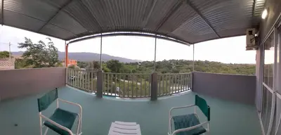 a room with chairs and a balcony with a view at La Casita de Caeiro in Bialet Massé
