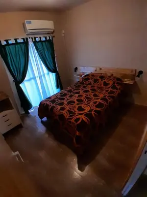 a bedroom with a bed and a large window at La Casita de Caeiro in Bialet Massé