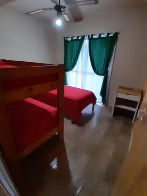 a bedroom with a red bed and a window at La Casita de Caeiro in Bialet Massé