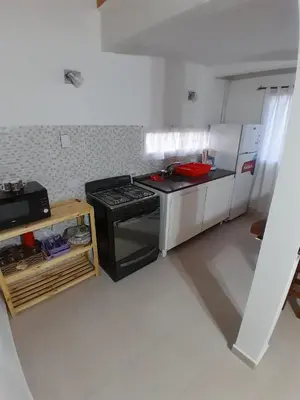 a small kitchen with a stove and a refrigerator at La Casita de Caeiro in Bialet Massé