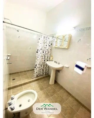 a bathroom with a sink and a toilet and a bidet at Casa Der Wandel in Villa General Belgrano