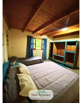 a bedroom with two beds with blue curtains at Casa Der Wandel in Villa General Belgrano