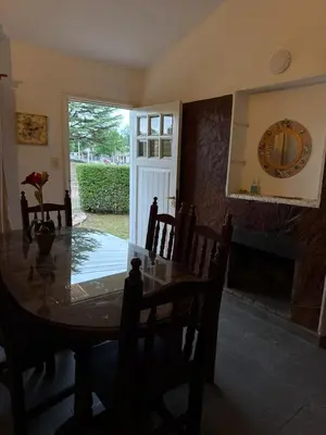 a dining room with a table and a fireplace at cabaña EL CHALECITO DE ANA in Villa del Dique