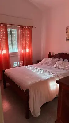 a bedroom with a large bed with red curtains at cabaña EL CHALECITO DE ANA in Villa del Dique