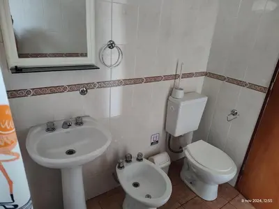 a white bathroom with a sink and a toilet at Cabañas Las Glicinas in Las Rabonas