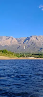 a large body of water with mountains in the background at Cabañas Las Glicinas in Las Rabonas
