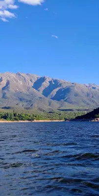 a large body of water with mountains in the background at Cabañas Las Glicinas in Las Rabonas