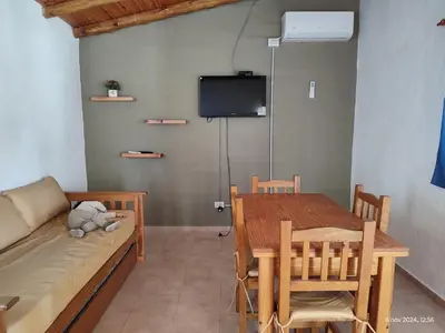 a room with a couch and a table and a tv at Cabañas Las Glicinas in Las Rabonas