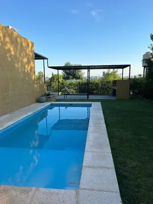 a swimming pool in the backyard of a house at HERMOSO DEPARTAMENTO en COMPLEJO CERRADO in Estancia Vieja