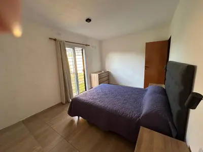 a bedroom with a blue bed and a window at HERMOSO DEPARTAMENTO en COMPLEJO CERRADO in Estancia Vieja