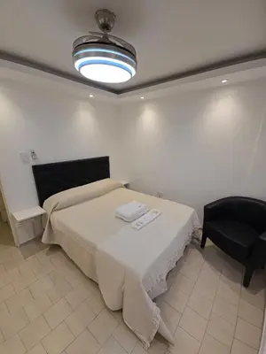 a bedroom with a bed and a black chair at Departamento en Bv San Juan a cuadras del shopping Patio Olmos in Cordoba