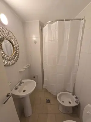 a white bathroom with a toilet and a sink at Departamento en Bv San Juan a cuadras del shopping Patio Olmos in Cordoba