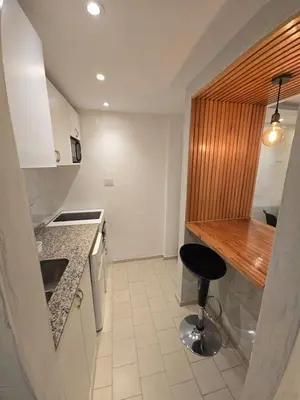 a small kitchen with a stool and a counter at Departamento en Bv San Juan a cuadras del shopping Patio Olmos in Cordoba
