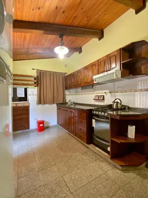 a kitchen with wooden cabinets and a stove at Finca - CASONA LAS MANSAS in Bialet Massé