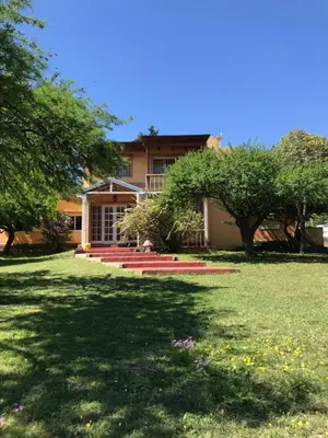 a house with trees in front of a yard at Finca - CASONA LAS MANSAS in Bialet Massé