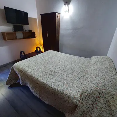 a bedroom with a bed with a blanket on it at Casa con pileta en Cabalango - Sierras de Córdoba IG alquilervillacarlospaz in Cavalango