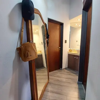 a mirror with a purse hanging on a wall at Casa con pileta en Cabalango - Sierras de Córdoba IG alquilervillacarlospaz in Cavalango