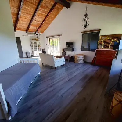 a bedroom with a bed and a living room at Casa con pileta en Cabalango - Sierras de Córdoba IG alquilervillacarlospaz in Cavalango