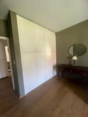 a room with white cabinets and a table and a mirror at casa santa rita in Villa Carlos Paz