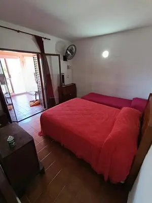 a bedroom with a red bed with a red blanket at Elena in San Antonio de Arredondo