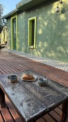 a wooden table with two bowls and bread on it at Zelenaiplava dormis in Merlo
