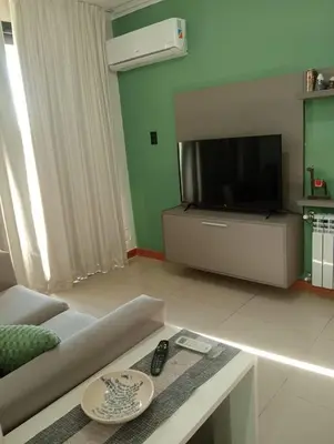 a living room with a couch and a tv at Constantino Villa Carlos Paz departamento céntrico in Villa Carlos Paz