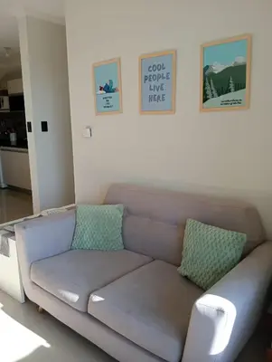 a couch in a living room with pictures on the wall at Constantino Villa Carlos Paz departamento céntrico in Villa Carlos Paz