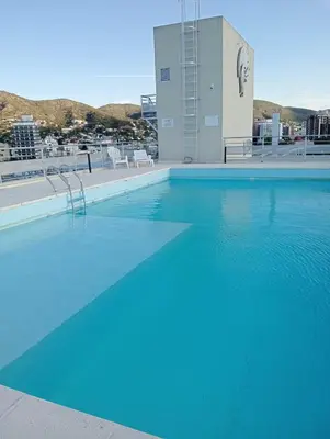 a large blue swimming pool on top of a building at Constantino Villa Carlos Paz departamento céntrico in Villa Carlos Paz