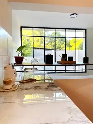 a living room with a table and some windows at La Casa del Mirador in Santa Rosa de Calamuchita