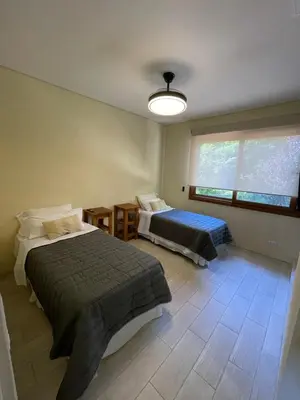 a bedroom with two beds and a large window at La Madruguera de Potrerillo in Alta Gracia