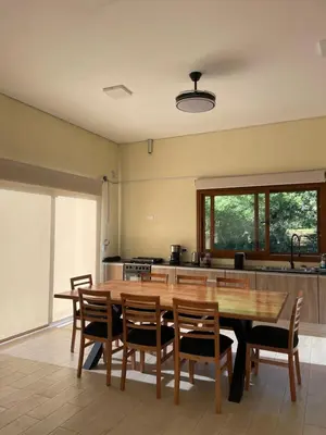 a large kitchen with a wooden table and chairs at La Madruguera de Potrerillo in Alta Gracia