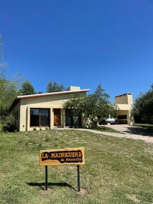a sign in the grass in front of a building at La Madriguera de Potrerillo in Alta Gracia