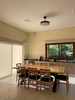 a large kitchen with a wooden table and chairs at La Madriguera de Potrerillo in Alta Gracia