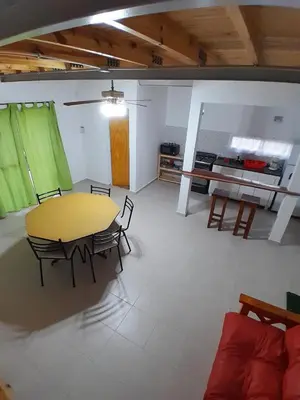 a room with a table and chairs and a kitchen at La Casita de Caeiro in Bialet Massé