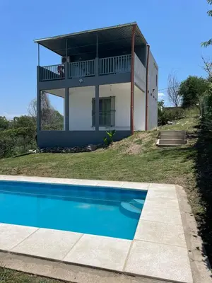 a house with a swimming pool in front of it at La Casita de Caeiro in Bialet Massé