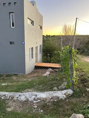 a building with a bench next to a fence at La Casita de Caeiro in Bialet Massé