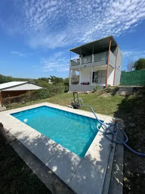 a house with a swimming pool in front of a house at La Casita de Caeiro in Bialet Massé