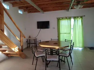 a dining room with a wooden table and chairs at La Casita de Caeiro in Bialet Massé