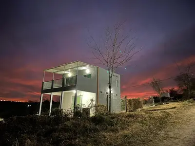 a building with glass windows on the side of a road at La Casita de Caeiro in Bialet Massé